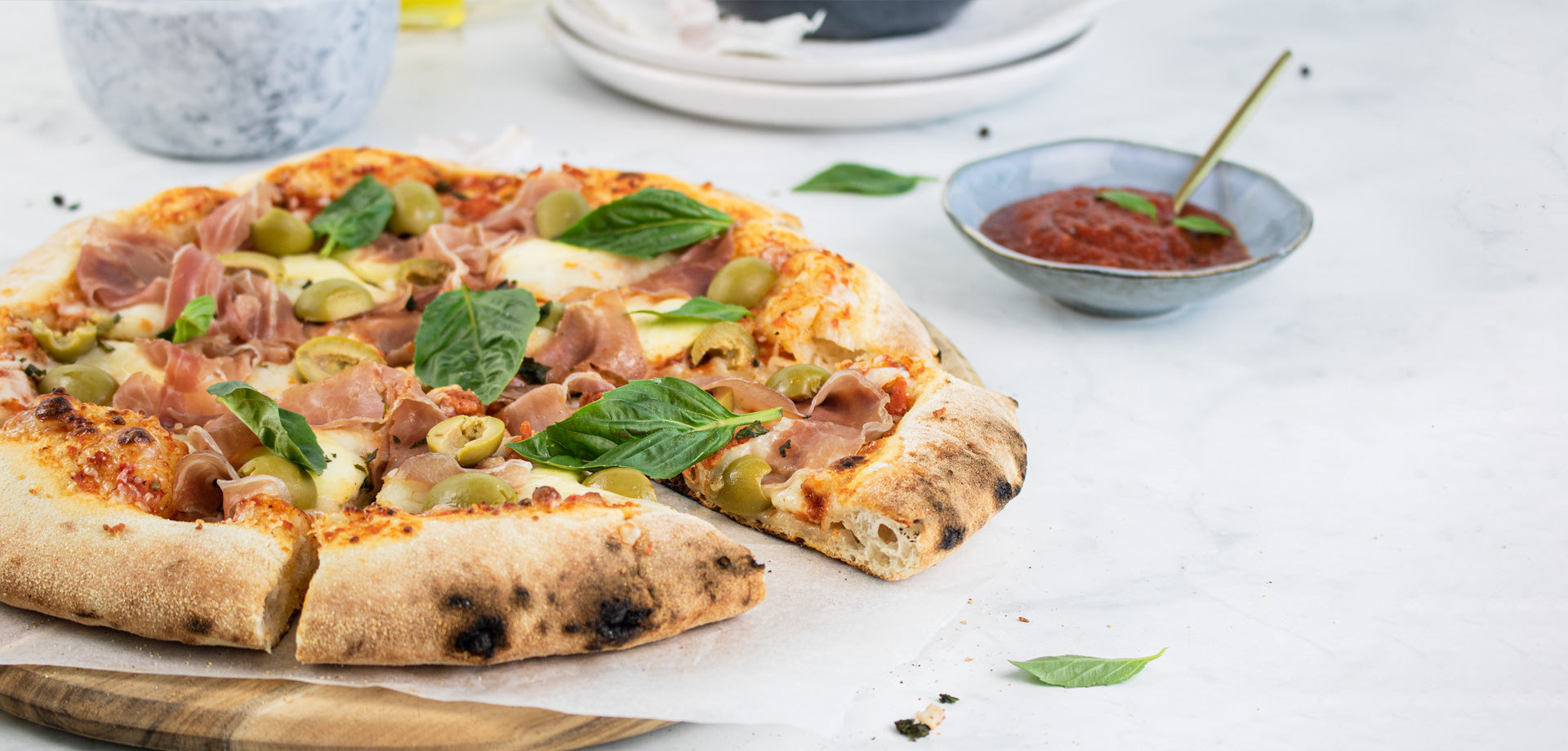 Sliced pizza with fresh basil on wooden board Sliced pizza with fresh basil on wooden board